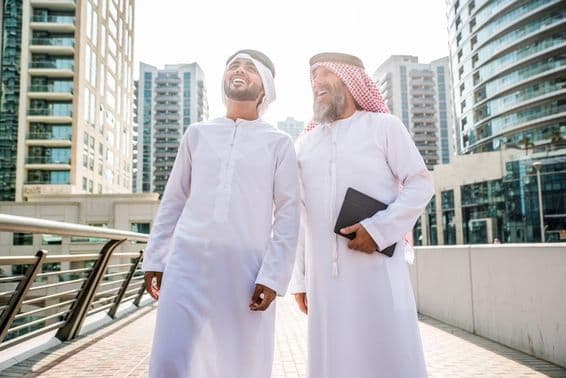 Deux hommes d'affaires en tenue traditionnelle émiratie se rencontrant à Dubaï.
