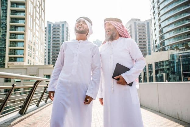 Deux hommes d'affaires en tenue traditionnelle émiratie se rencontrant à Dubaï.