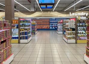 Section de produits ménagers et lessive dans un supermarché.