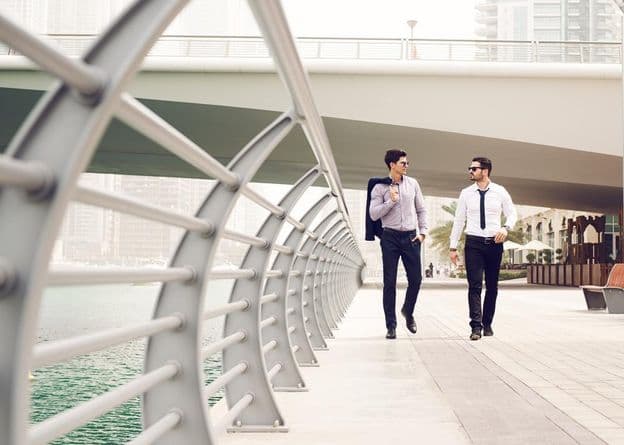 Hommes d'affaires marchant à la Marina de Dubaï.