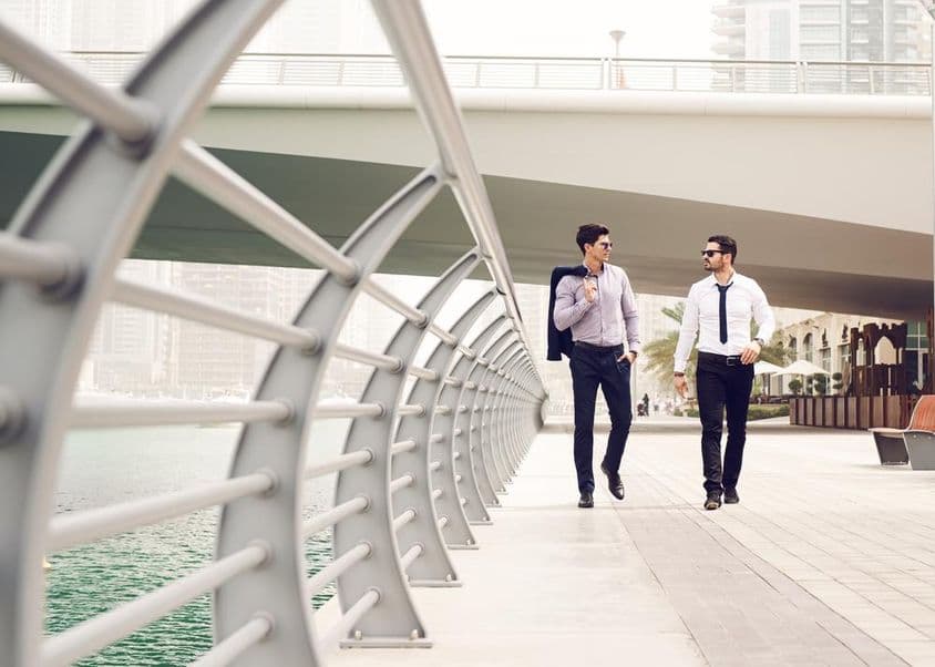 Hommes d'affaires marchant à la Marina de Dubaï.