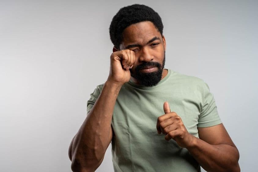 Une personne se frottant les yeux de manière inconfortable, se sentant irritée et fatiguée.