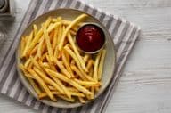 Frites maison et ketchup sur une assiette.
