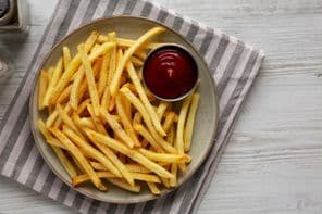 Frites maison et ketchup sur une assiette.
