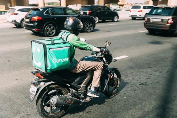 Coursier Careem livrant de la nourriture sur un scooter.