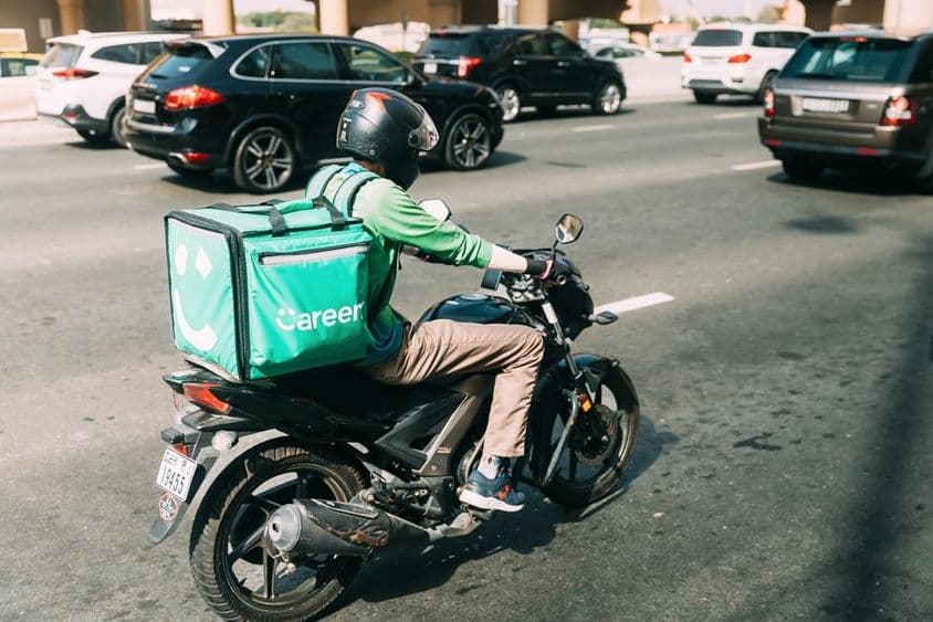 Coursier Careem livrant de la nourriture sur un scooter.