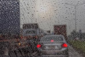 Pluie vue à travers une vitre de voiture.