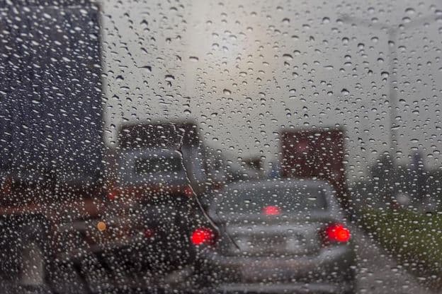 Pluie vue à travers une vitre de voiture.