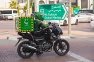 Motocycliste du service de livraison écologique vert de Careem.