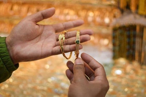 Une main essayant un bracelet en or de luxe