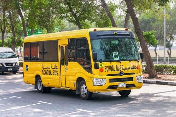 Bus scolaire Toyota Coaster sur une rue de Dubaï.