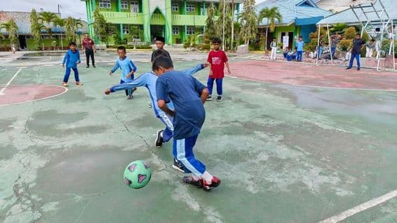 élèves de l'école primaire jouant au foot
