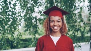 étudiant diplômé heureux en robe rouge