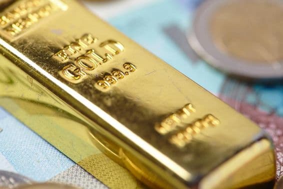 lingots d'or empilés sur des billets de banque