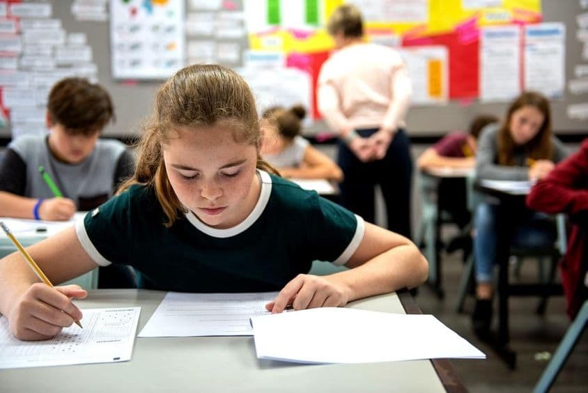Élèves passant des examens dans une salle de classe.