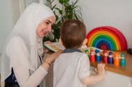 Un enseignant musulman et un enfant de maternelle jouant avec des jouets colorés