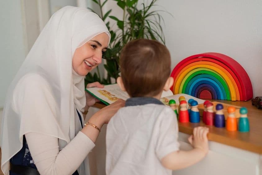 Un enseignant musulman et un enfant de maternelle jouant avec des jouets colorés