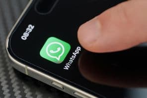 Doigt touchant l'icône de l'application WhatsApp