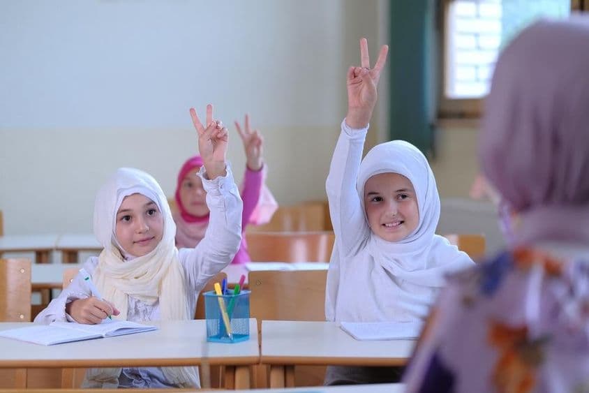 Des élèves musulmans levant la main pour répondre aux questions des enseignants.