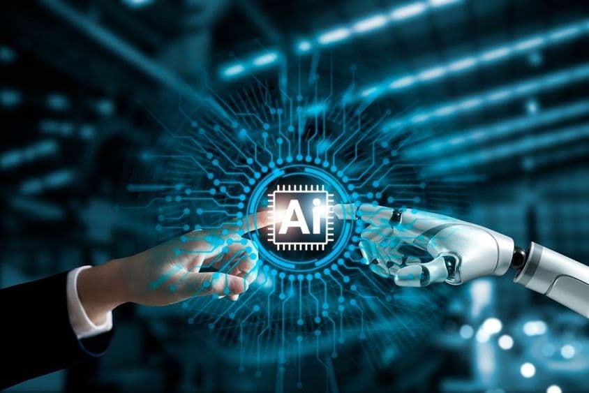Les mains d'un robot et celles d'un humain connectant un circuit imprimé d'IA.