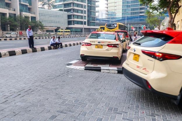 Un groupe de chauffeurs de taxi attendant des passagers devant un hôtel de Dubaï.