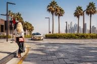 Femme debout dans la rue, attendant un taxi.