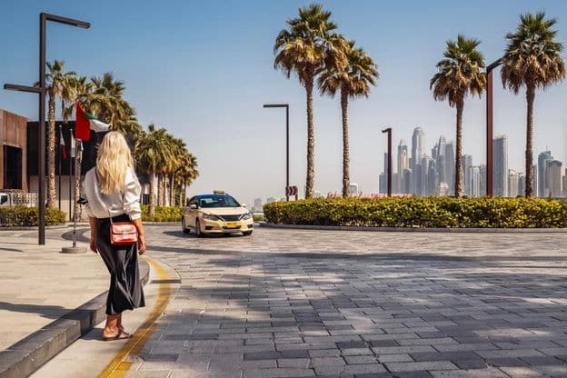 Femme debout dans la rue, attendant un taxi.