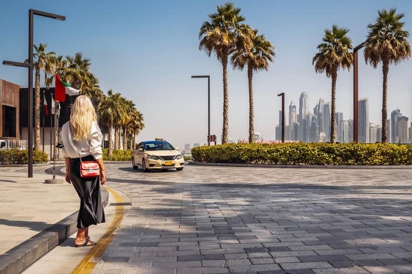 Femme debout dans la rue, attendant un taxi.