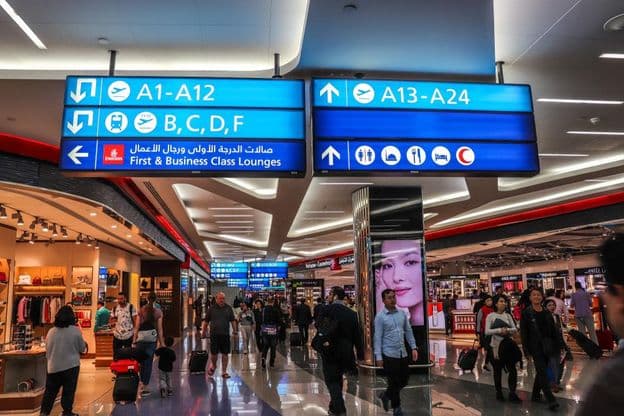 Des passagers marchant vers les portes d'embarquement à l'aéroport international de Dubaï