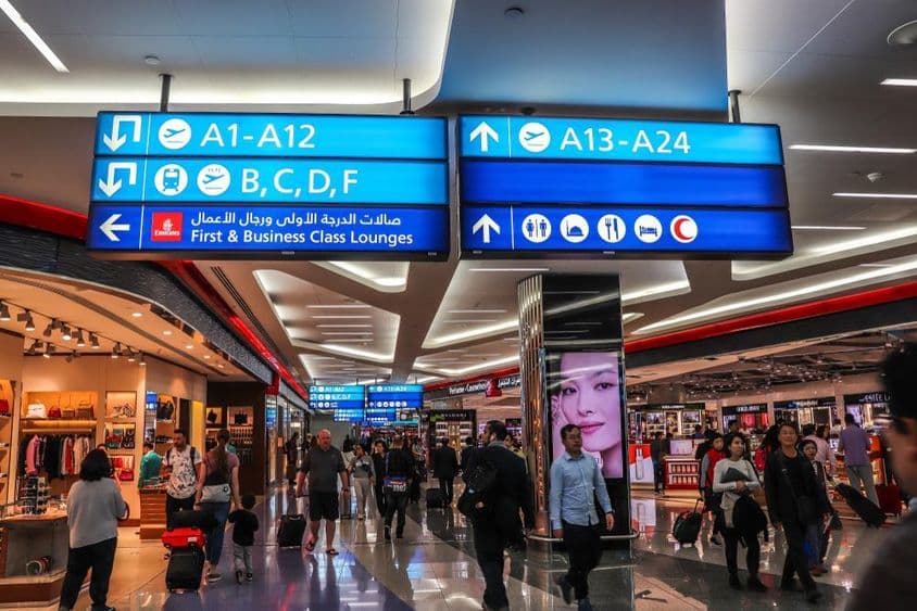 Des passagers marchant vers les portes d'embarquement à l'aéroport international de Dubaï