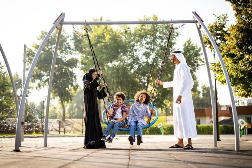 une famille jouant à l'aire de jeux à Dubaï