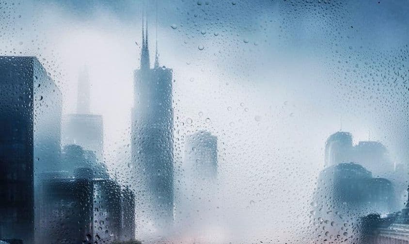 Vue urbaine à travers une fenêtre lors d'une nuit pluvieuse