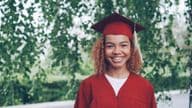 diplômé heureux en robe rouge