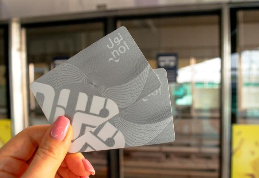 Une femme tenant deux cartes NOL de métro dans sa main