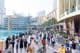 Une foule diverse de touristes et de locaux marche le long de la promenade animée devant le Dubai Mall.